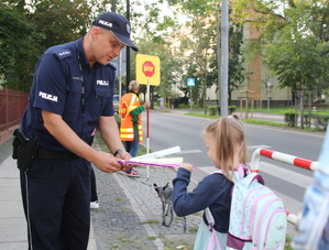 policjant rozdaje dzieciom odblaski