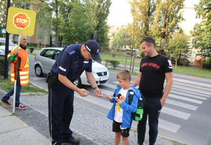 policjant rozdaje dzieciom odblaski