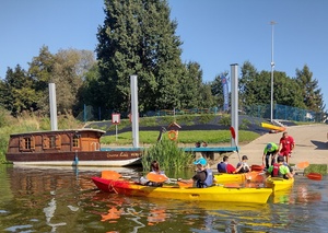 grupa osób pływa kajakami