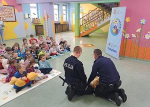policjanci ćwiczą z dziećmi pierwszą pomoc