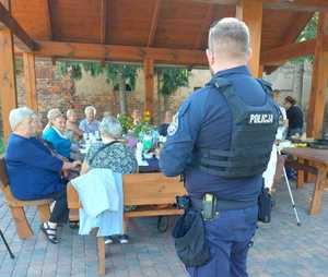 policjant i grupa kobiet pod altaną