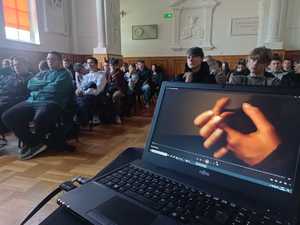 laptop, w tle grupa młodzieży