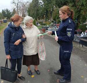 policjantka rozdaje elementy odblaskowe