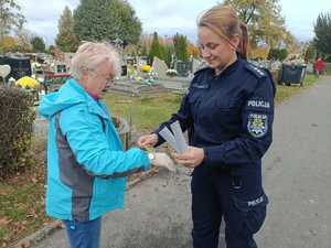 policjantka rozdaje elementy odblaskowe