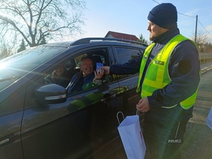 policjant przekazuje kierowcy alkotest