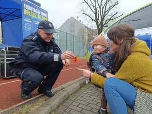 policjant przekazuje dziecku odblask