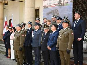 Grupa osób w mundurach i garniturach