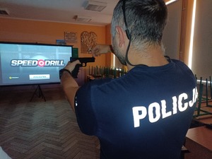 policjant pokazuje broń na strzelnicy wirtualnej