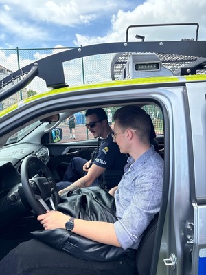 policjant i uczeń siedzą w radiowozie