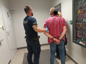 policjanci prowadzą zatrzymanego