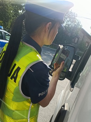 policjantka trzyma urządzenie do badania stanu trzeźwości