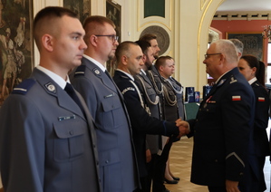 komendant policji wręcza rozkaz policjantowi