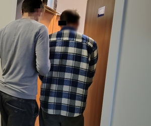 nieumundurowany policjant prowadzi zatrzymanego