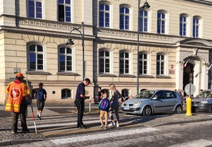 policjant rozdaje odblaski w rejonie przejścia dla pieszych