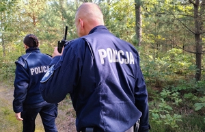 policjanci idą przez las
