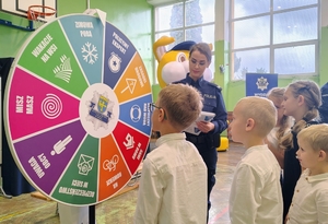 policjantka z dziećmi gra w koło fortuny