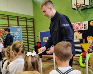 policjant przekazuje dzieciom naklejki