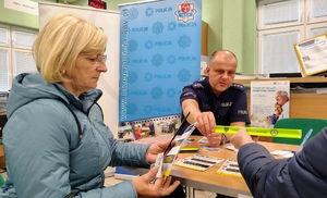 policjant przekazuje seniorom odblaski