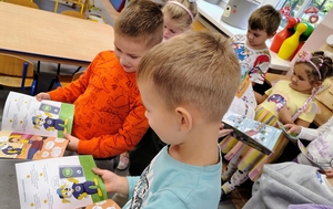 dzieci oglądają książeczkę