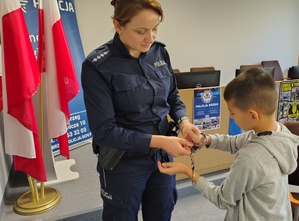 policjantka prezentuje dziecku kajdanki