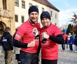 grupa osób w białych i czerwonych koszulkach z orłem