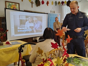 policjant rozdaje seniorom lupki