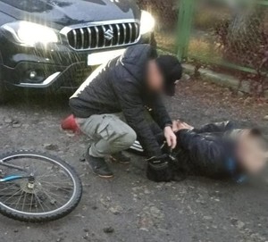 policjant zakłada kajdanki poszukiwanemu