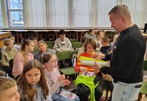 mężczyzna rozdaje odblaski