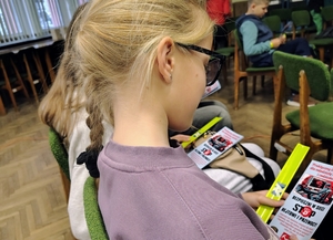dziewczynka czyta ulotkę