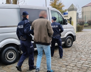 policjanci prowadzą zatrzymanego