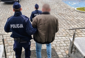 policjanci prowadzą zatrzymanego
