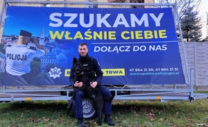 policjant siedzi na kole przyczepy
