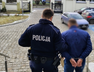 policjanci prowadzą zatrzymanego mężczyznę