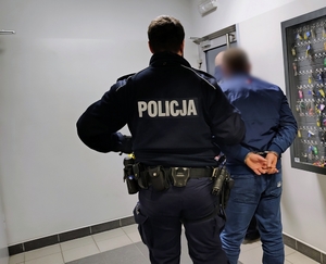 policjanci prowadzą zatrzymanego mężczyznę