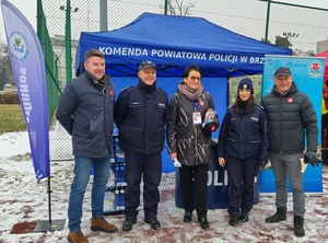 na tle niebieskiego namiotu stoją osoby