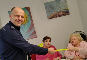 policjant przekazuje elementy odblaskowe seniorom