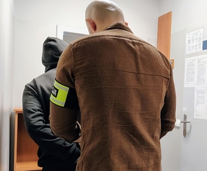 policjant zapina kajdanki mężczyźnie