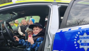 grupa dzieci przy policyjnym radiowozie i maskotce