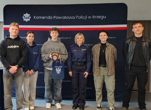 młodzież z policjantką na tle granatowego baneru