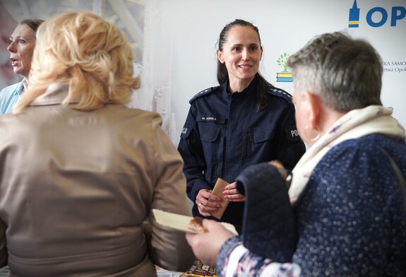 uśmiechnięta policjantka rozmawia z seniorami