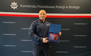 umundurowani policjanci na tle granatowej ścianki