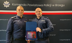 umundurowani policjanci na tle granatowej ścianki