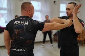 dwóch mężczyzn demonstruje chwyty samoobrony