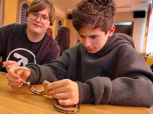 młodzież zakłada sobie policyjne kajdanki