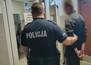 policjant prowadzi zatrzymanego
