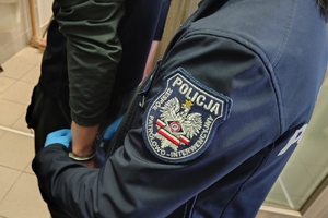 policjant zapina kajdanki zatrzymanemu