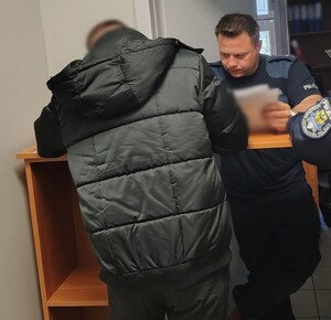 mężczyzna podpisuje dokumenty w obecności policjanta