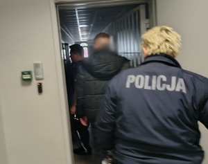 mężczyzna podpisuje dokumenty w obecności policjanta