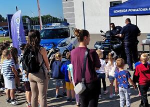 grupa dzieci rozmawia z policjantami