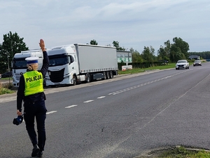 policjantka z żółtej kamizelce zatrzymuje pojazd